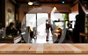 Empty wood table top with blur of people in coffee shop