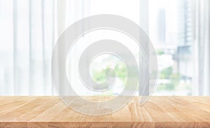 Empty of wood table top on blur of white curtain with window view background