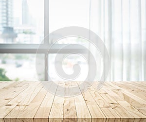 Empty of wood table top on blur of white curtain with window view background