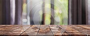 Empty wood table top and blurred living room in home interior with curtain window background. - can used for display or montage