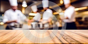 Empty Wood table top with Chef cooking in restaurant kitchen blurred defocused background