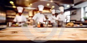 Empty Wood table top with Chef cooking in restaurant kitchen blurred defocused background