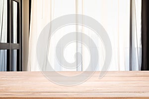 Empty wood table top with Defocused of curtain window in living room with sunlight