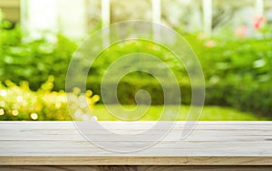 Empty wood table top on lawn green from garden in morning