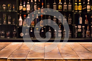 Empty wooden bar counter with defocused background and bottles of restaurant