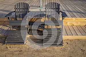 Empty wooden beach chairs at the edge of a deck