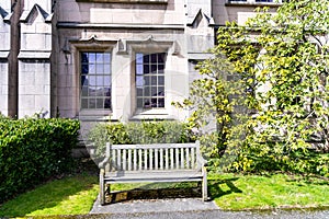 empty wooden bench at house with windows