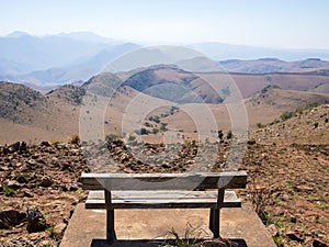 Empty wooden bench overlooking mountains and arid landscape of Malolotja Nature Reserve, Swaziland, Southern Africa