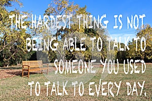 Empty wooden bench seat in a park in autumn with a quote abou