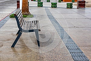 Empty wooden bench on sidewalk of promenade