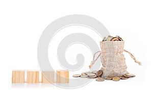 Empty wooden blocks and money bags with coins on white background.Time to invest, time value for money, money saving, finance