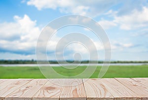 Empty wooden board table top on of blurred blue sky and river  background. with copy space for display or montage your products