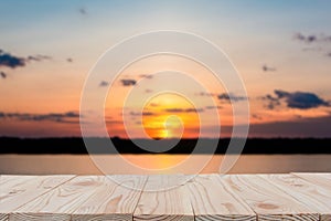 Empty wooden board table top on of blurred sunset and lake background. with copy space for display or montage your products