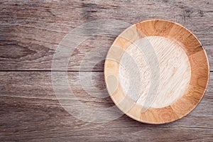 Empty wooden bowl on wooden table top view