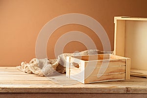 Empty wooden box on rustic table with sackcloth over wall background.  Farmer market mock up for design and product display
