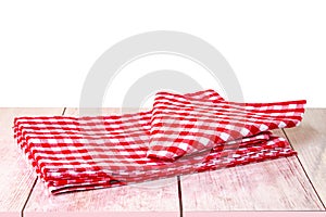 Empty wooden bright desk table with red checkered tablecloth isolated on a white background. Template for your food and product