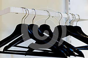 Empty wooden clothes hangers in empty cloakroom,Hangers row all black.Empty wardrobe stand with black hangers at