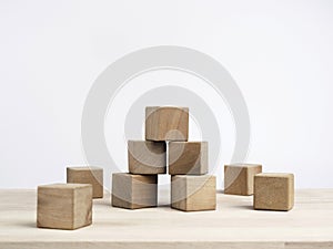 Empty wooden cube blocks on the table on white background. Many wood bricks building tower construction.