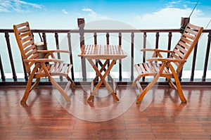 Empty wooden deck chairs and table on ship.