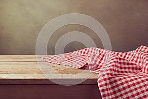 Empty wooden deck table with checked tablecloth for product montage display