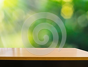 Empty wooden deck table with foliage bokeh background