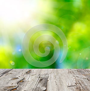 Empty wooden deck table with foliage bokeh background.