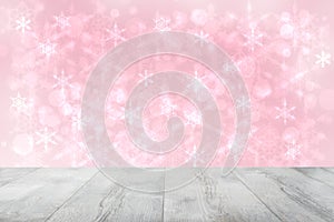 Empty wooden deck table over abstract blurred light pink christmas background texture with stars. Template for your product