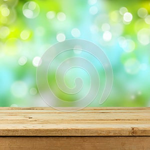 Empty wooden deck table over blurred bokeh nature background