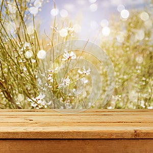 Empty wooden deck table over blurred bokeh summer flowers background for product montage