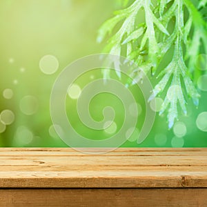 Empty wooden deck table over green nature background for product montage