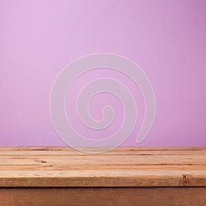 Empty wooden deck table over purple violet wallpaper. Easter spring background