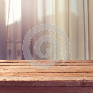 Empty wooden deck table over window curtains background