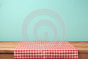 Empty wooden deck table and red checked tablecloth