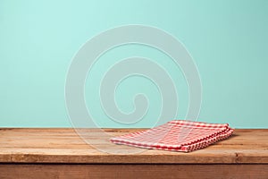 Empty wooden deck table and red checked tablecloth