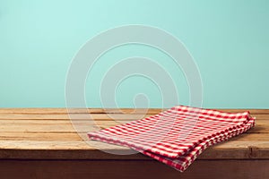 Empty wooden deck table and red checked tablecloth