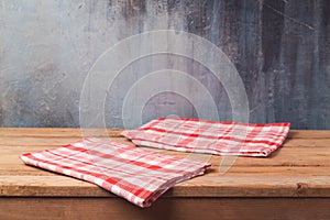 Empty wooden deck table with tablecloth over painted wall background