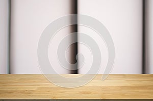 empty wooden desk over blurred coffee shop cafe background