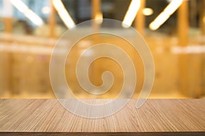 empty wooden desk over blurred coffee shop cafe background