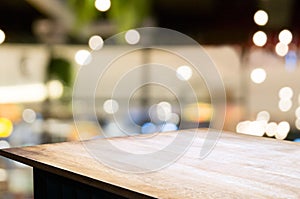 empty wooden desk over blurred coffee shop cafe background