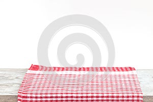 Empty wooden desk table and red checked tablecloth over mint wallpaper background
