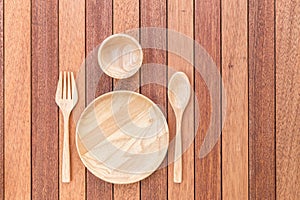 Empty wooden dish, fork, spoon and bowl on wooden table