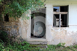 Empty wooden door frame with missing doors on abandoned dilapidated stone house