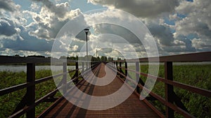 Empty wooden footbridge walking. Bridge connecting two shores of lake