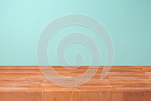 Empty wooden kitchen counter over mint wall background for product montage
