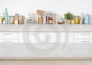 Empty wooden kitchen table on blurred background of food ingredients