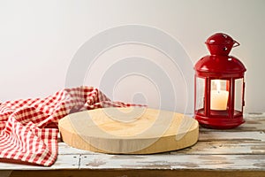 Empty wooden log with tablecloth and lantern on rustic table over white wall background.  Christmas and New Year mock up for