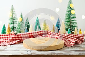 Empty wooden log with tablecloth on rustic table over Christmas tree decoration background.  Christmas and New Year mock up for
