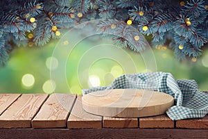 Empty wooden log with tablecloth on table over beautiful pine tree branches background.  Christmas holiday mock up for design and