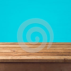 Empty wooden old table over blue wall background for product montage