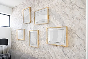 Empty wooden picture frames, poster, blank canvas, mock up, on a marble wall, living room, gallery template